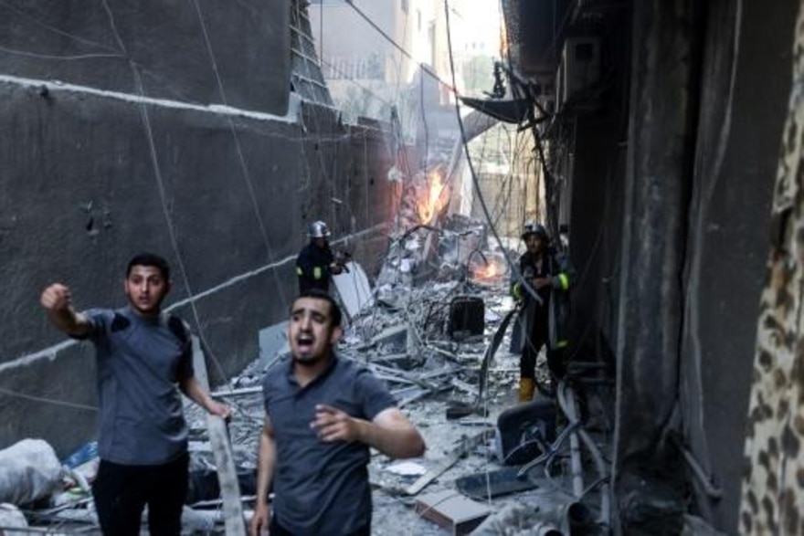  عمال إغاثة وسط الدمار إثر ضربة جوية صهيونية على غزة في 05/08/2022 (فرانس بريس)