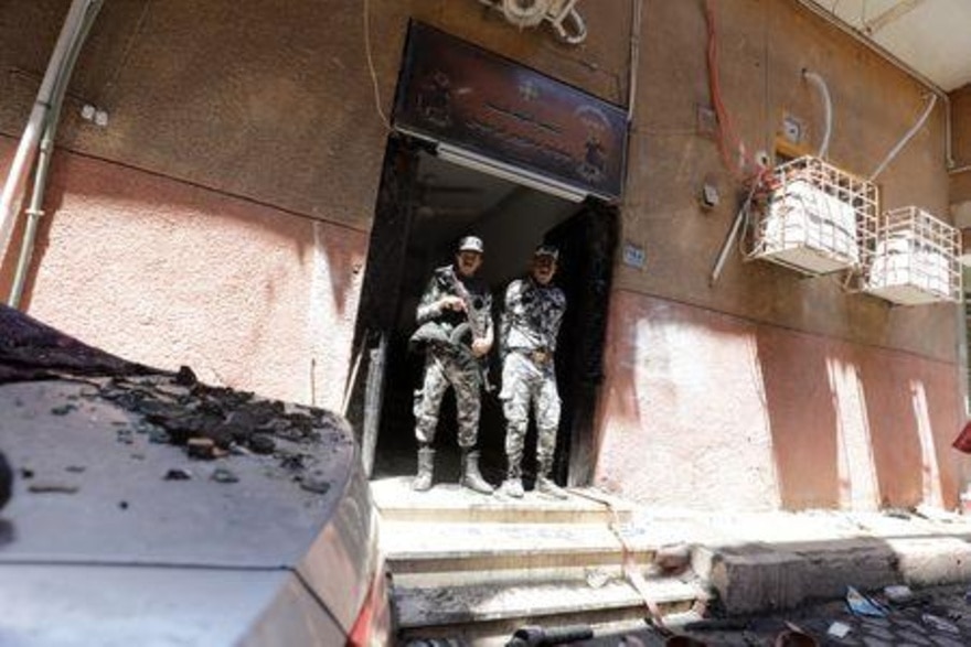  مجندان يقفان عند مدخل كنيسة أبو سيفين في الجيزة بعد اندلاع حريق اليوم الأحد.(رويترز)